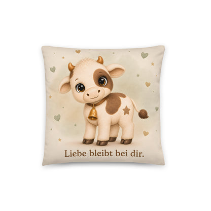 Cremefarbenes Muki-Dekokissen mit Kuh, goldener Herzglocke, salbeigrünen Herzen und dem Spruch Liebe bleibt bei dir.